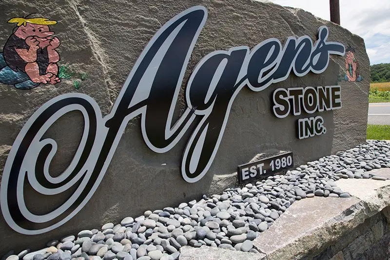 A sign that says agens stone inc.