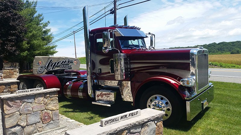 A red and black truck parked on the grass.